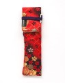 Rolowane etui Taccia Kimono Sakura Festival w kolorze czerwonym z czarnymi i złotymi motywami kwiatowymi, przewiązane sznurkiem.