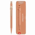 Ołówek automatyczny Caran d’Ache 844 Brut Rose w kolorze różowego złota obok dopasowanego etui Slimpack.