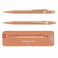 Ołówek automatyczny Caran d’Ache 844 Brut Rose w kolorze różowego złota obok dopasowanego etui Slimpack.