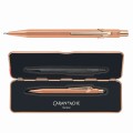 Ołówek automatyczny Caran d’Ache 844 Brut Rose w kolorze różowego złota obok dopasowanego etui Slimpack.