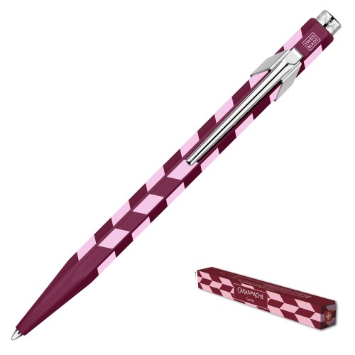 Długopis Caran d’Ache 849 Mosaic Garnet Red ustawiony pod kątem z widocznym symbolem Swiss Made oraz małe opakowanie z flagą Szwajcarii.