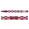 Długopis Caran d’Ache 849 Mosaic Garnet Red w kolorze granatowej czerwieni z różową mozaiką nad pasującym etui.