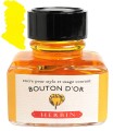 Atrament J. Herbin 30ml Bouton d'or w szklanym kałamarzu z plastikową zakrętką i wbudowaną podstawką na pióro.