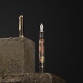 artystyczna-kompozycja-piora-pelikan-m600-i-skuwki-na-kamiennym-bloku-ciemne-tlo