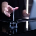 Długopis Novium Hoverpen Interstellar lewitujący w magnetycznej podstawie na ciemnym biurku obok laptopa