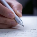 Zbliżenie na czubek srebrnego długopisu Novium Hoverpen Classic Starlight Silver piszącego w notesie