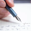 Zbliżenie na stalówkę niebieskiego pióra wiecznego Novium Hoverpen Future Deep Blue piszącego w notesie
